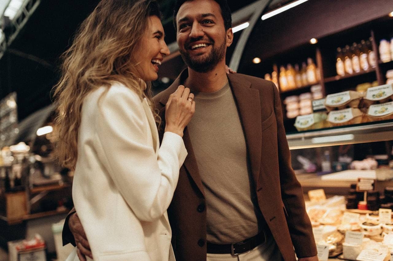 Un couple complice sous les halles, lumière chaude.