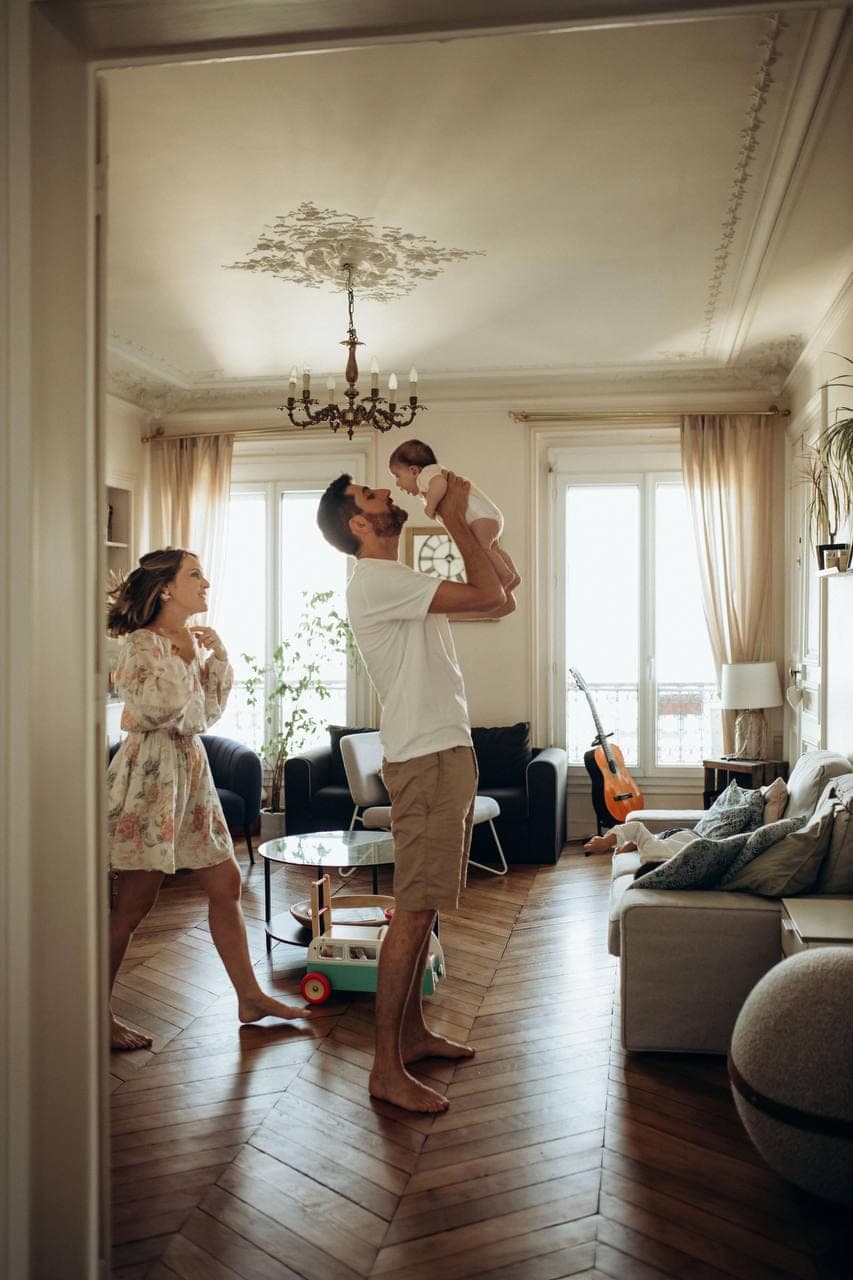Une famille à la maison, dans la lumière de la fenêtre.