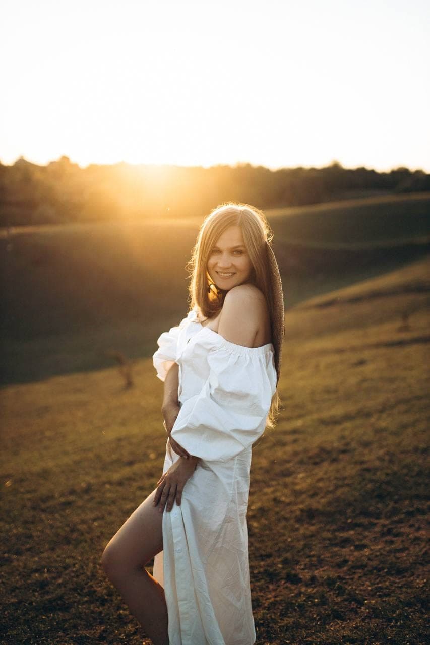 Portrait d'une femme en robe blanche, lumière dorée du soir.
