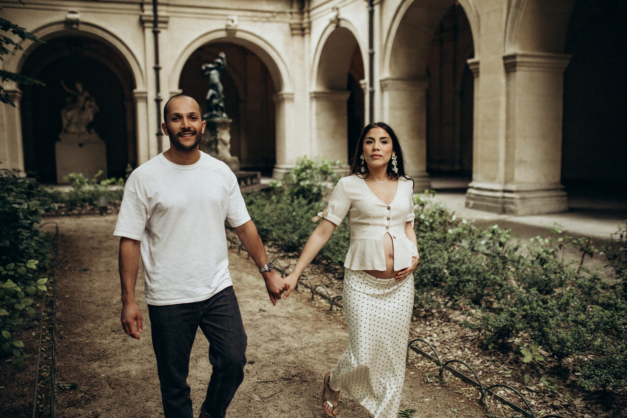 Un couple traverse la cour d'un palais lyonnais, main dans la main, avant la naissance.